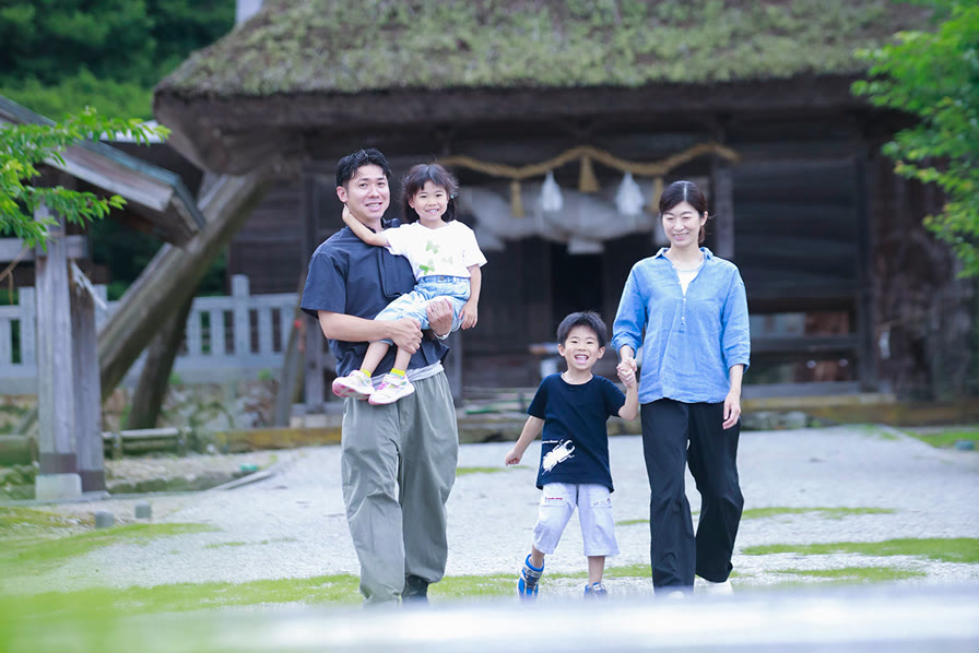 神社の前を歩く早川さん家族